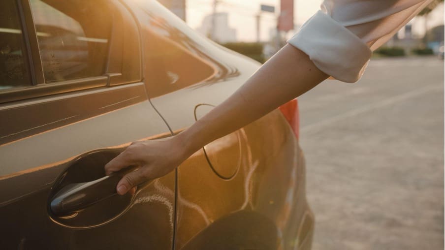 Close-up of a woman's hand with a silver ring, turning a door handle, symbolizing the unfolding legal developments in Uber sexual assault lawsuit cases.